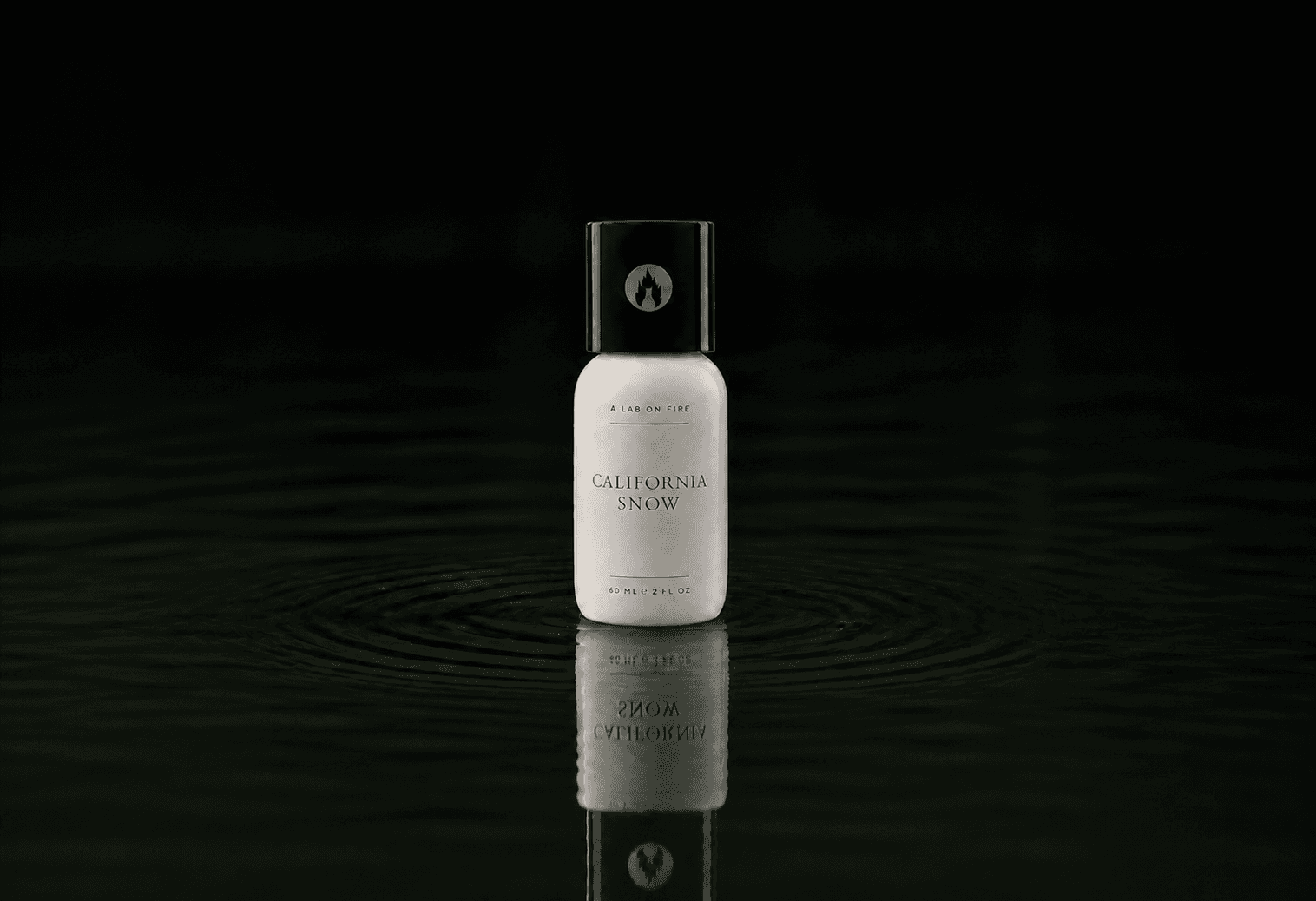 A Lab On Fire California Snow fragrance bottle floating above dark water