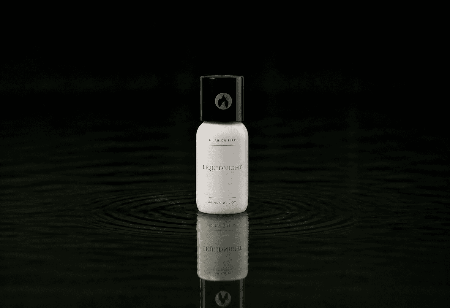 A Lab On Fire Liquid Night fragrance bottle floating above dark water