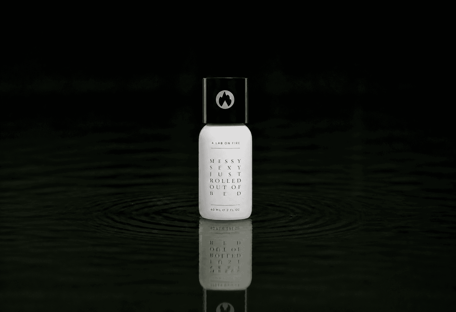 A Lab On Fire Messy Sexy Just Rolled Out of Bed fragrance bottle floating above dark water