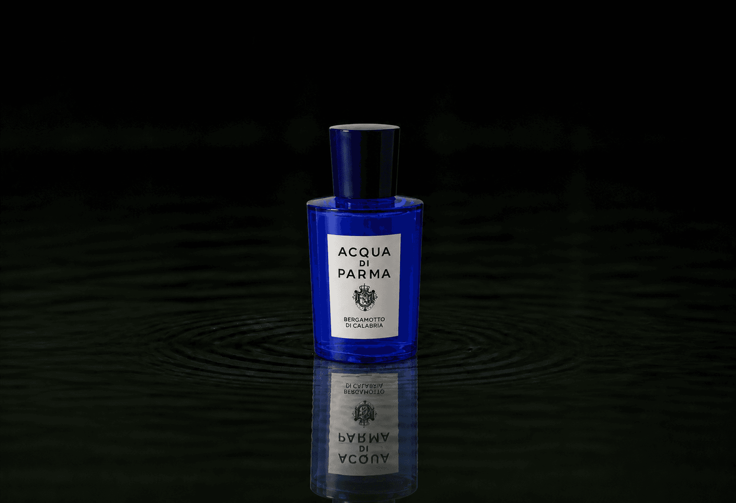 Acqua Di Parma Bergamotto fragrance bottle floating above dark water