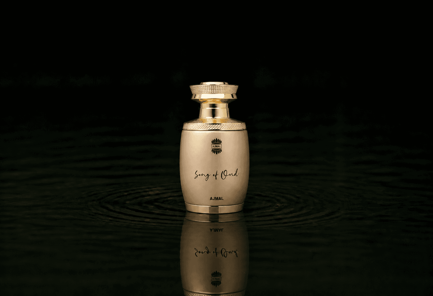 AJMAL Amber - Song Of Oud fragrance bottle floating above dark water