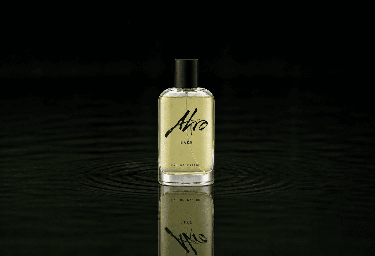 Akro Bake fragrance bottle floating above dark water