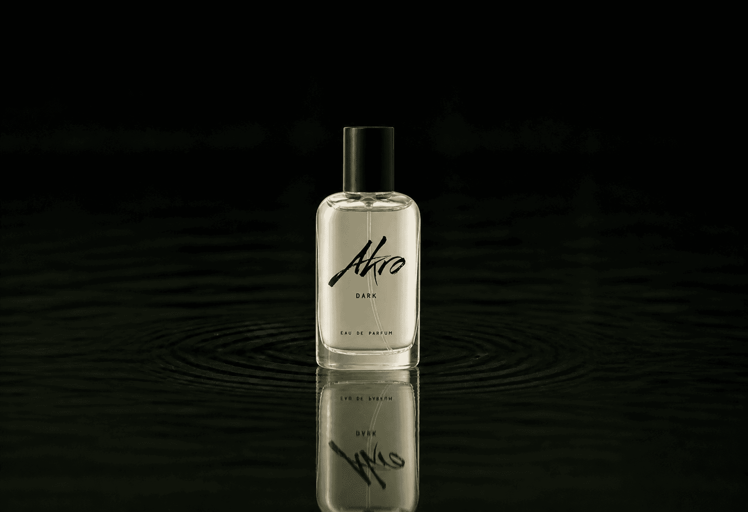 Akro Dark fragrance bottle floating above dark water
