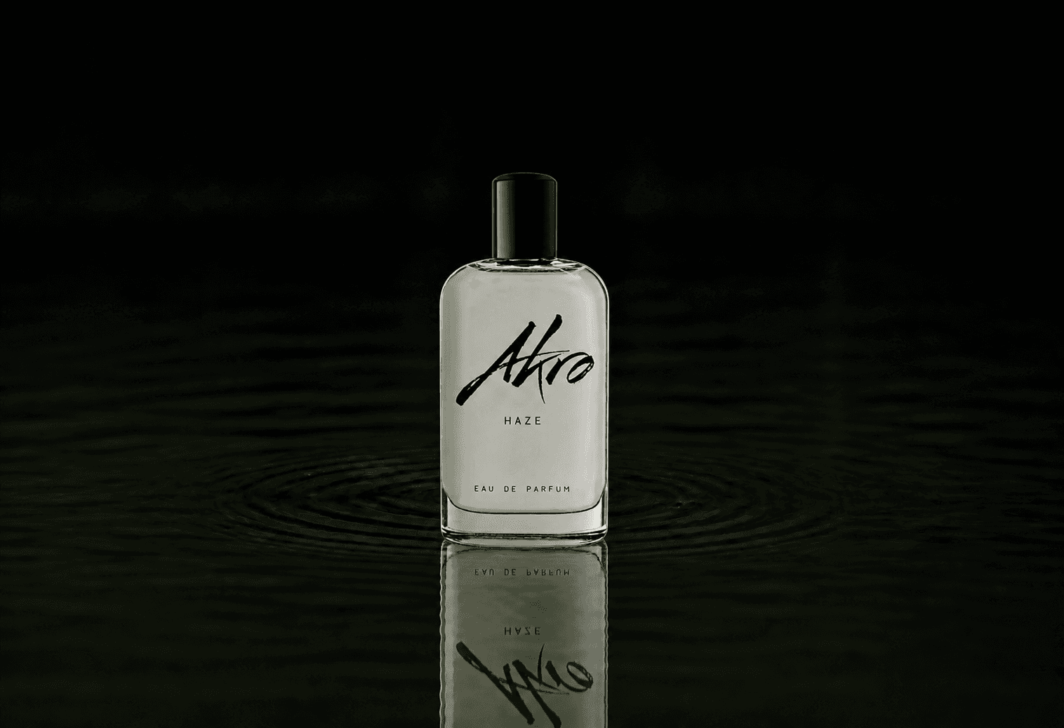 Akro Haze fragrance bottle floating above dark water
