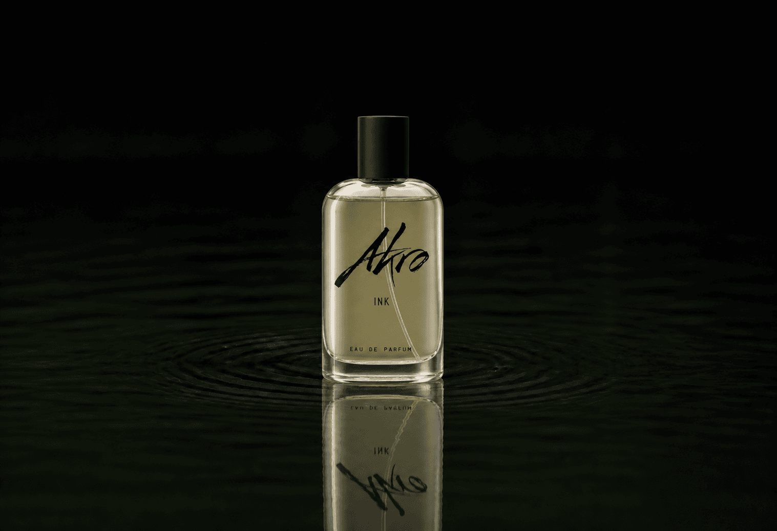 Akro Ink fragrance bottle floating above dark water