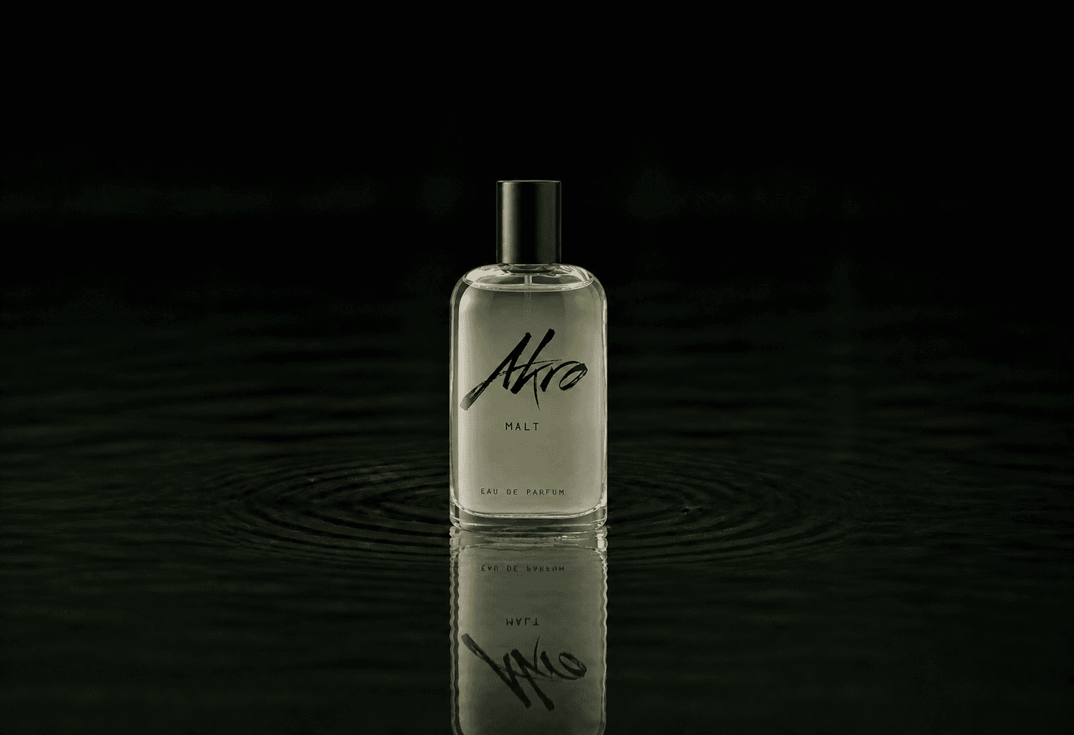 Akro Malt fragrance bottle floating above dark water