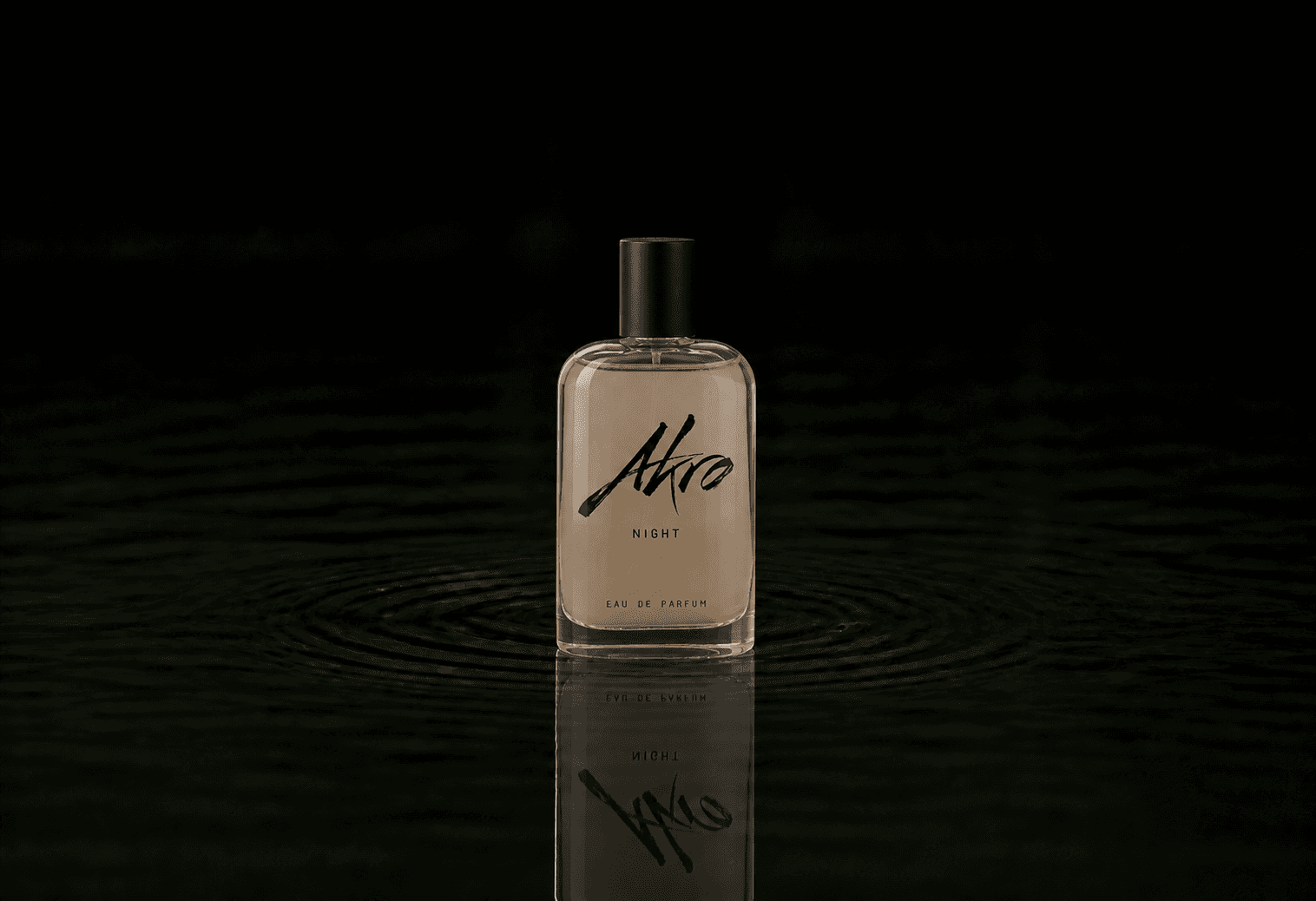Akro Night fragrance bottle floating above dark water