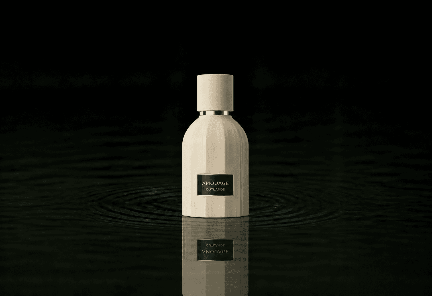 Amouage Outlands fragrance bottle floating above dark water
