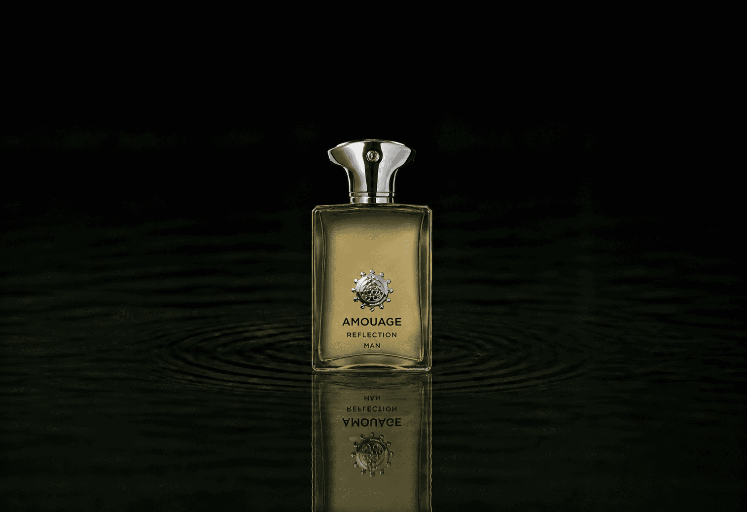 Amouage Reflection for Men fragrance bottle floating above dark water