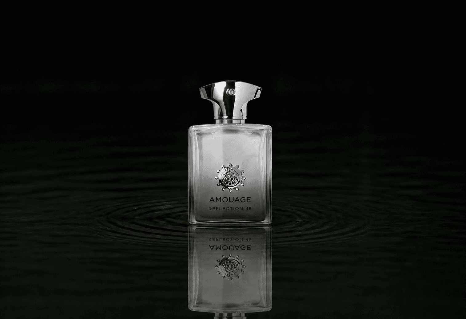 Amouage Reflection Man 45 Extrait fragrance bottle floating above dark water