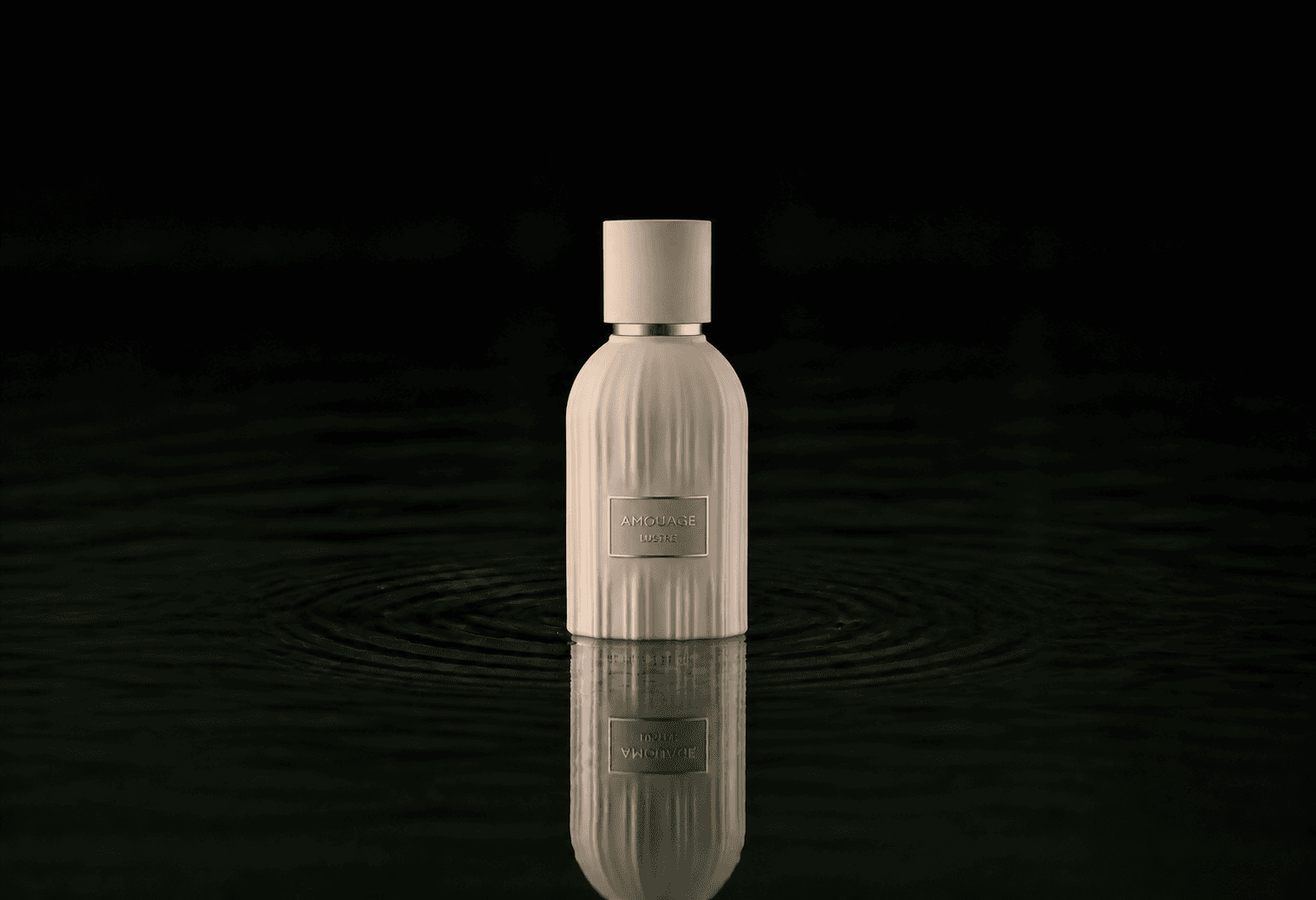 Amouage The Essences - Lustre fragrance bottle floating above dark water