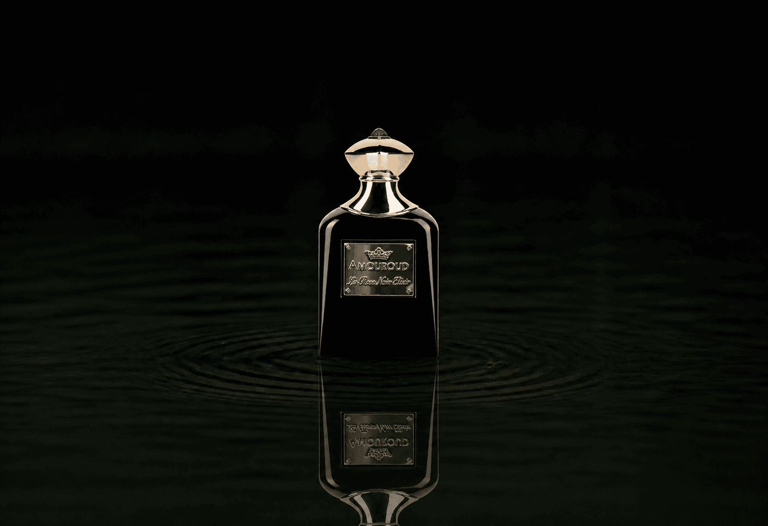 Amouroud La Rose Noir Elixir fragrance bottle floating above dark water