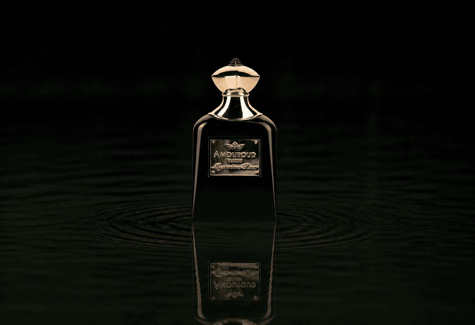 Amouroud Mysterious Rose Elixir fragrance bottle floating above dark water