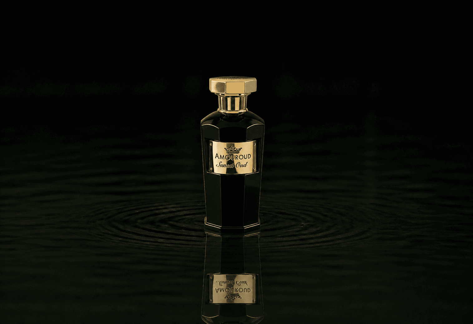Amouroud Sunset Oud fragrance bottle floating above dark water