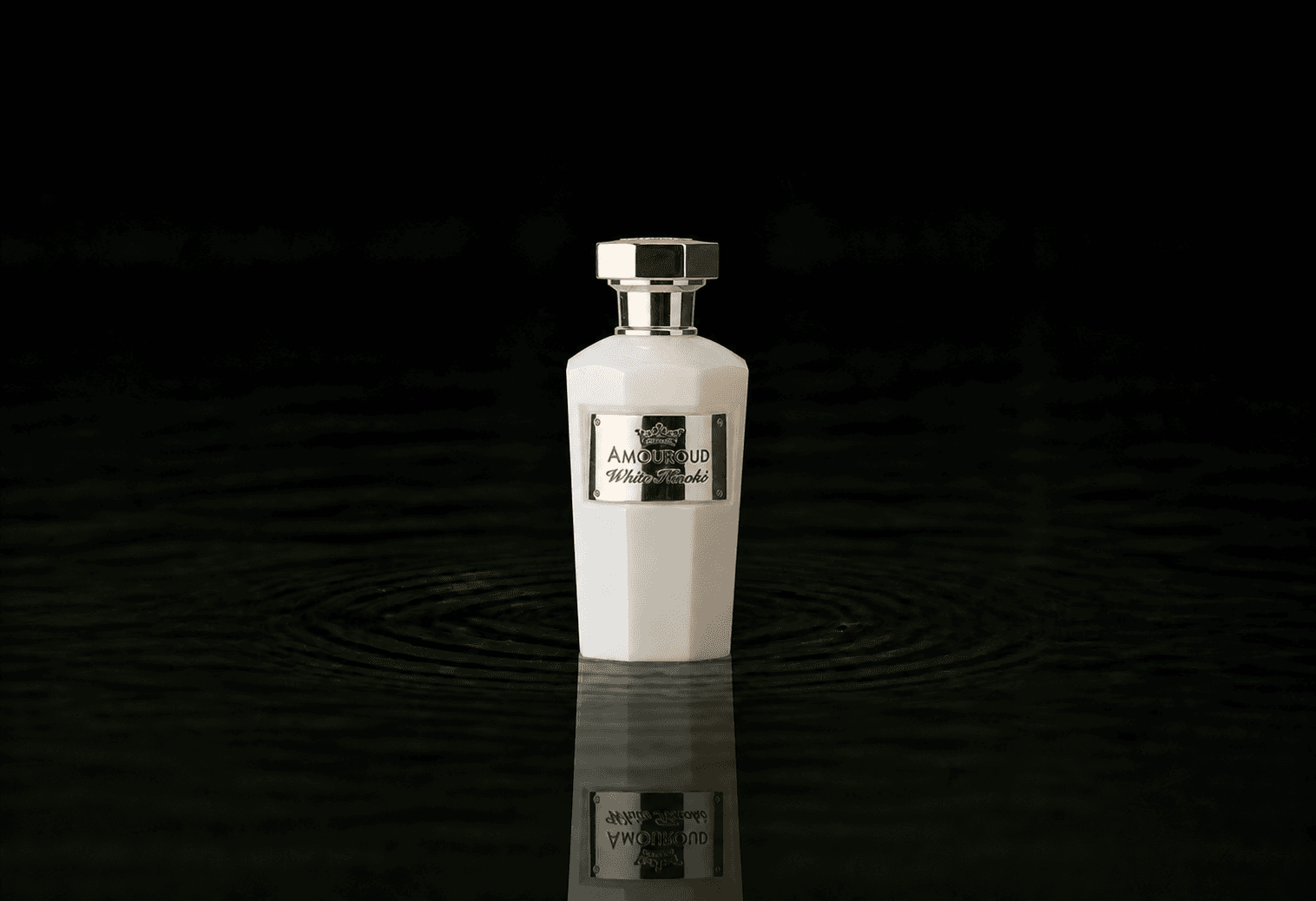 Amouroud White Hinoki fragrance bottle floating above dark water