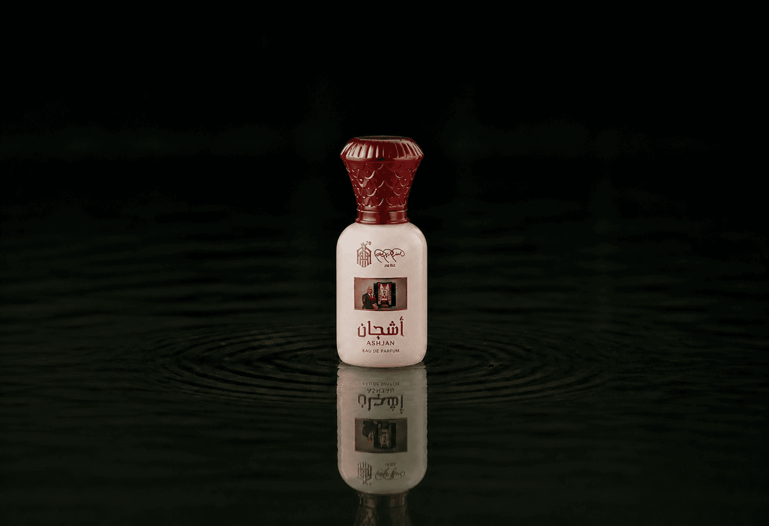 Asghar Adam Ali Ashjan fragrance bottle floating above dark water