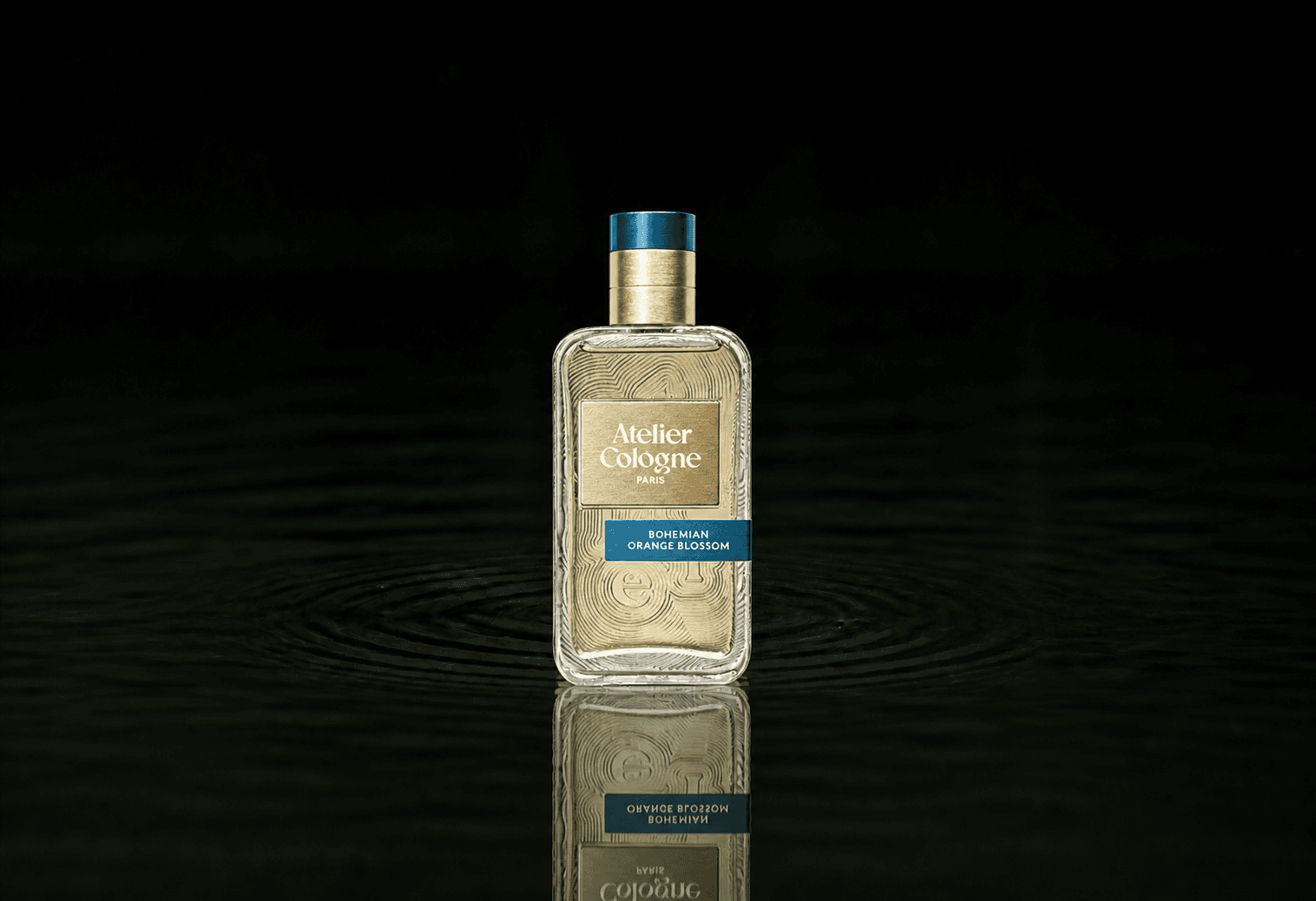 Atelier Cologne Bohemian Orange Blossom fragrance bottle floating above dark water