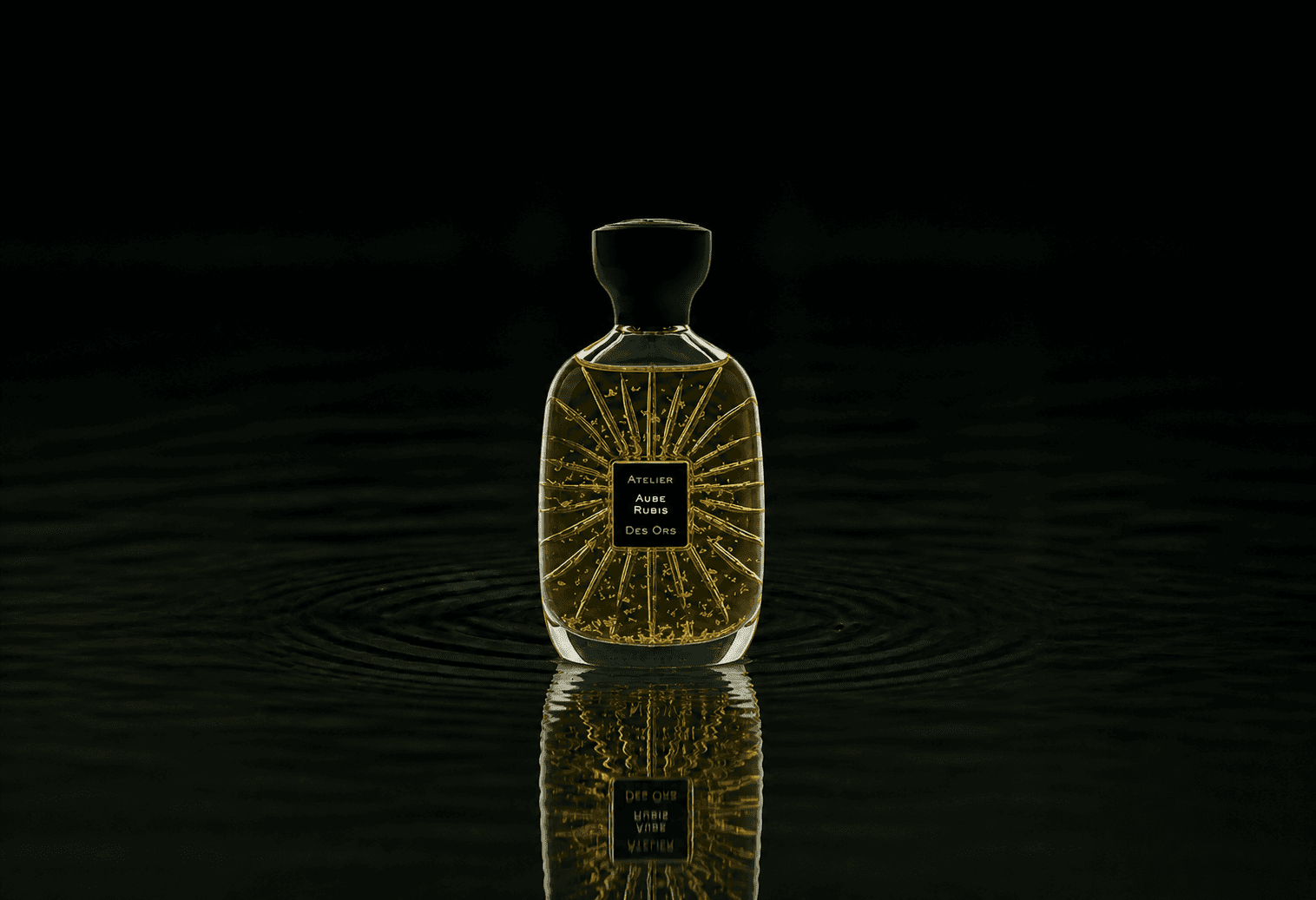 Atelier Des Ors Atelier Des Ors - Black Collection - Aube Rubis fragrance bottle floating above dark water