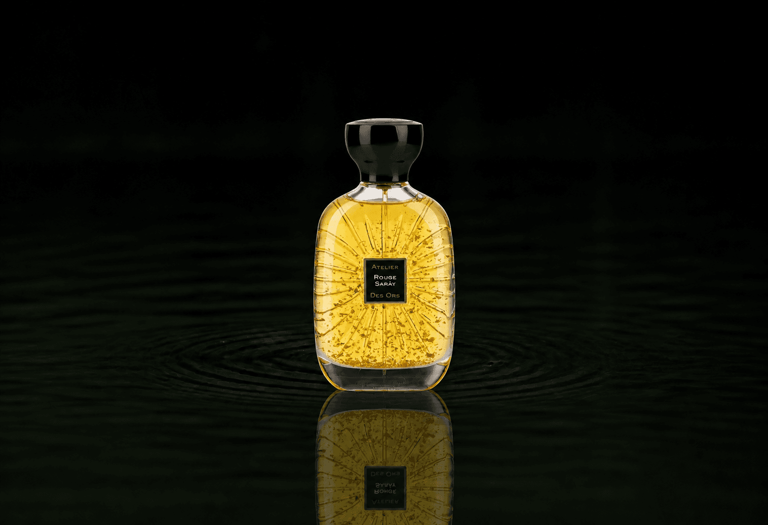 Atelier Des Ors Rouge Saray fragrance bottle floating above dark water