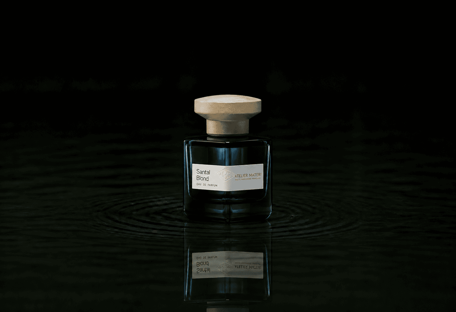 Atelier Materi Santal Blond fragrance bottle floating above dark water