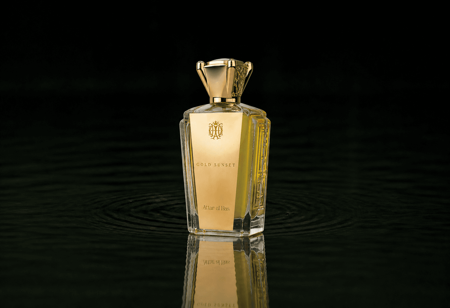 Attar Al Has Gold Sunset fragrance bottle floating above dark water