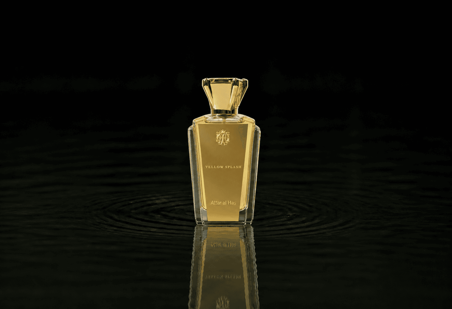 Attar Al Has Yellow Splash fragrance bottle floating above dark water