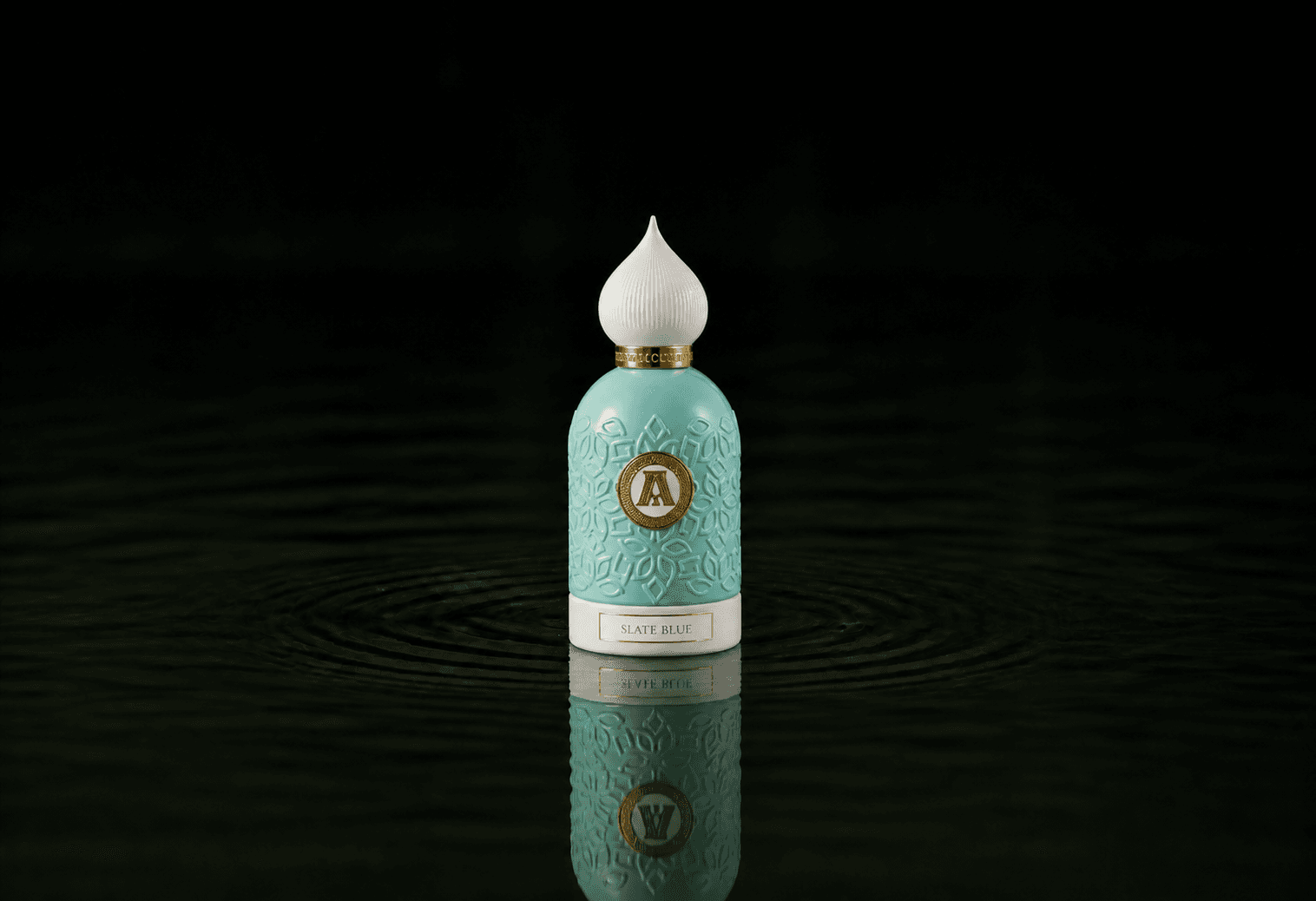 Attar Collection Attar - Slate Blue fragrance bottle floating above dark water