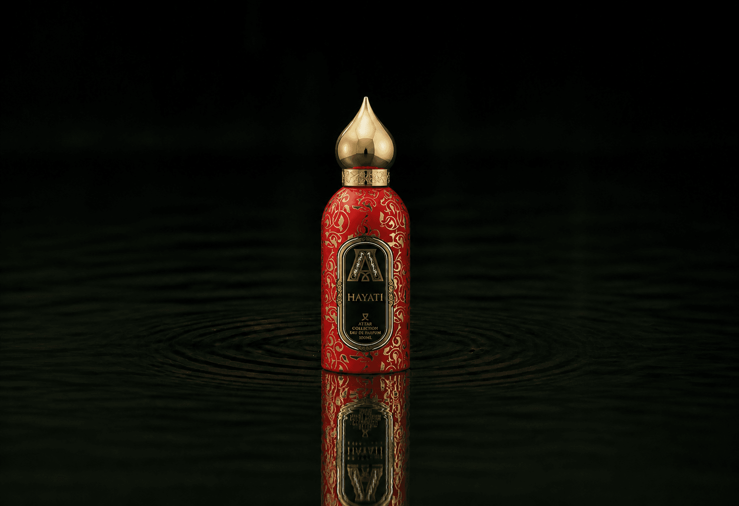 Attar Collection Hayati fragrance bottle floating above dark water