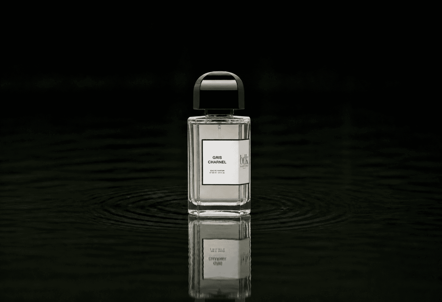 BDK Parfums Gris Charnel fragrance bottle floating above dark water