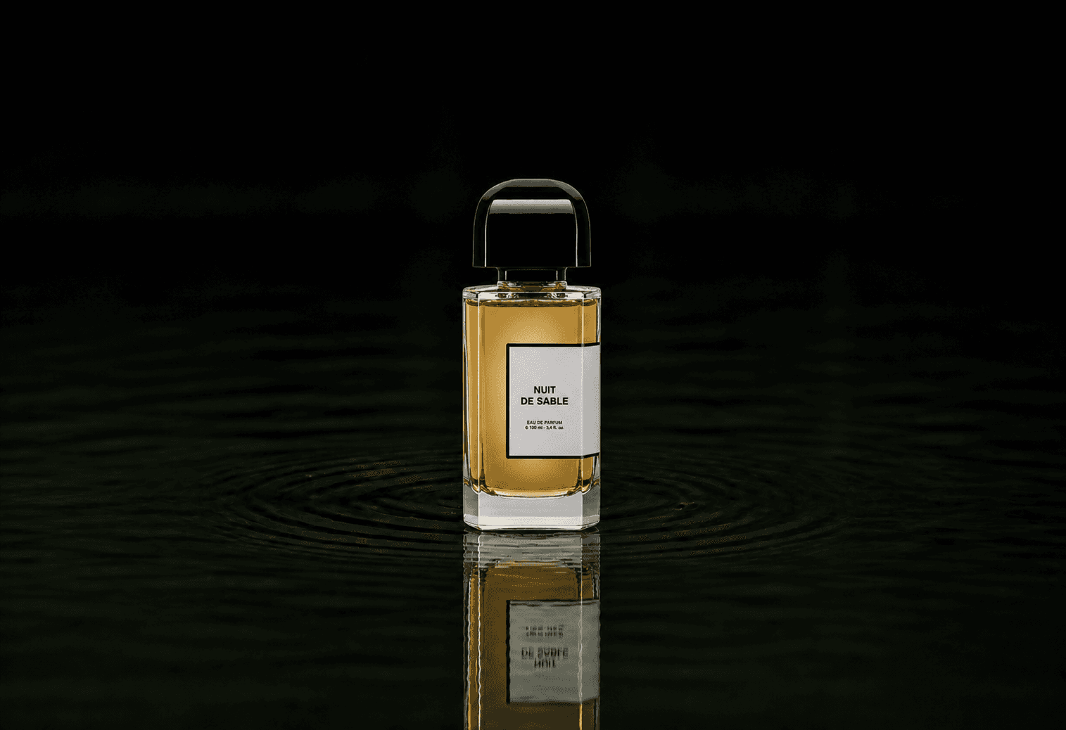 BDK Parfums Nuit de Sable fragrance bottle floating above dark water