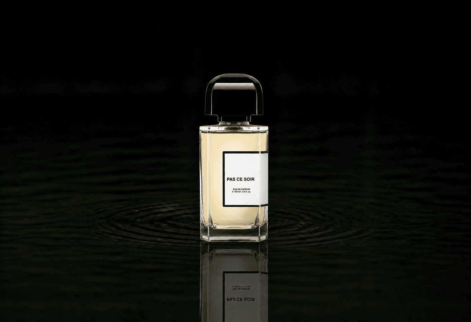 BDK Parfums Pas Ce Soir fragrance bottle floating above dark water