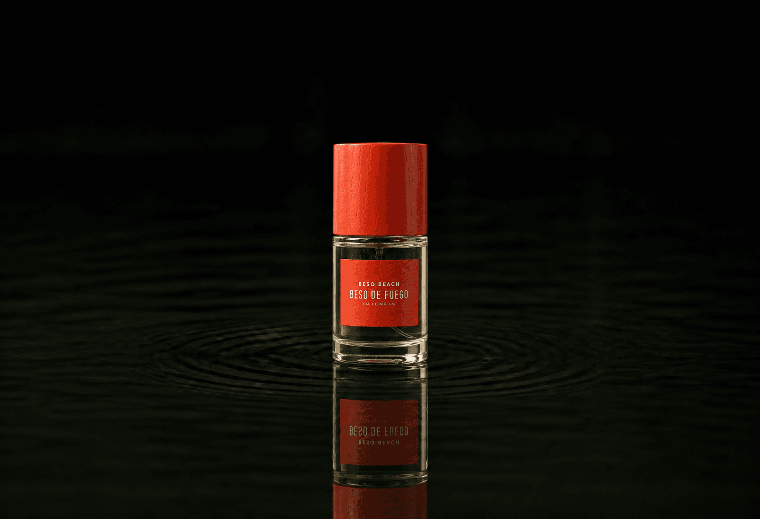 Beso Beach Beso De Fuego fragrance bottle floating above dark water
