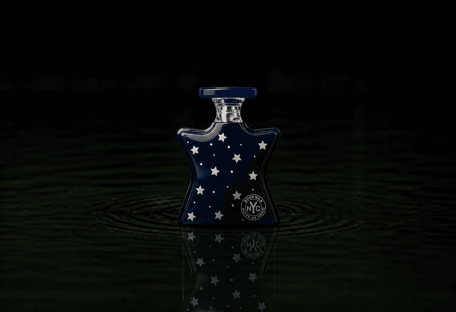 Bond No.9 Nuits De Noho fragrance bottle floating above dark water