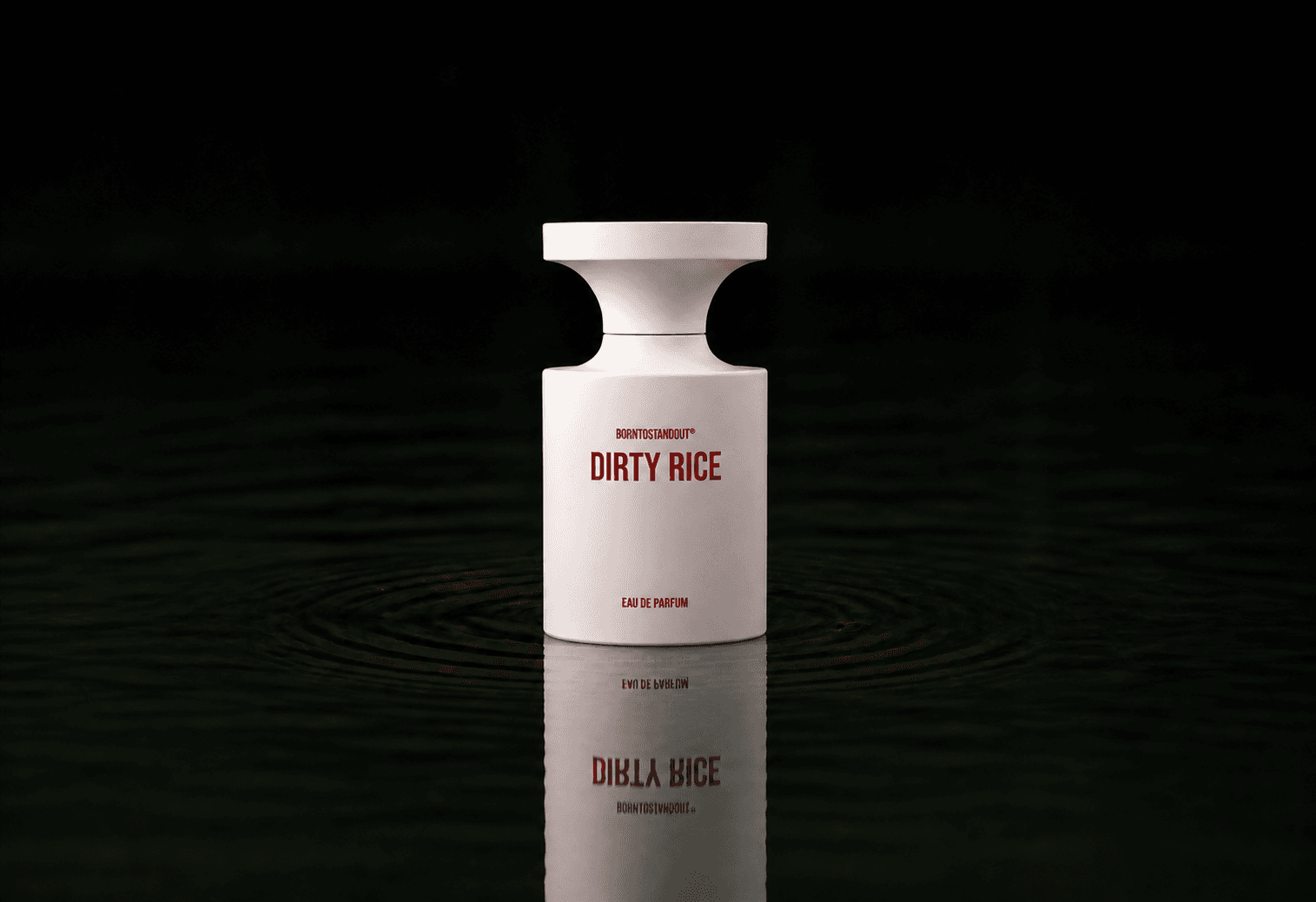 BORNTOSTANDOUT Dirty Rice fragrance bottle floating above dark water