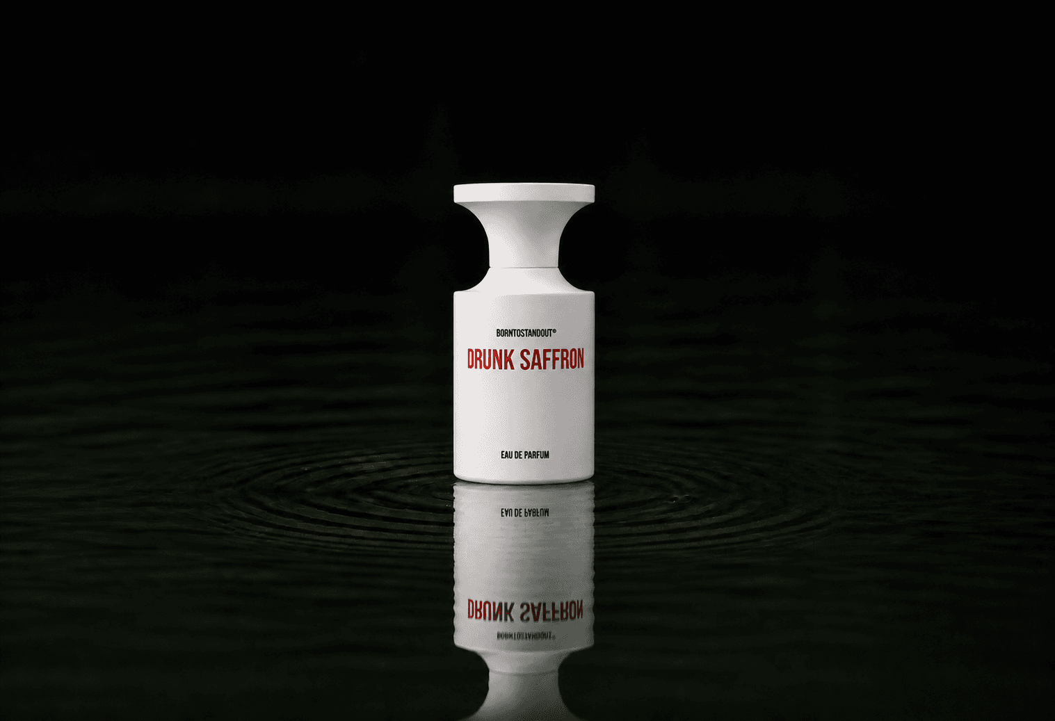 BORNTOSTANDOUT Drunk Saffron fragrance bottle floating above dark water