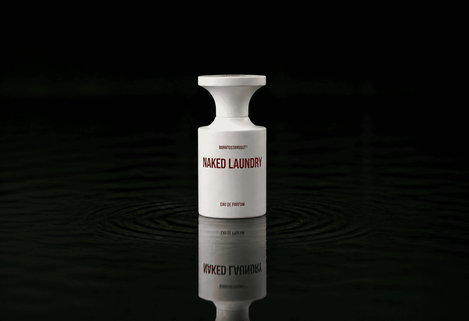 BORNTOSTANDOUT Naked Laundry fragrance bottle floating above dark water