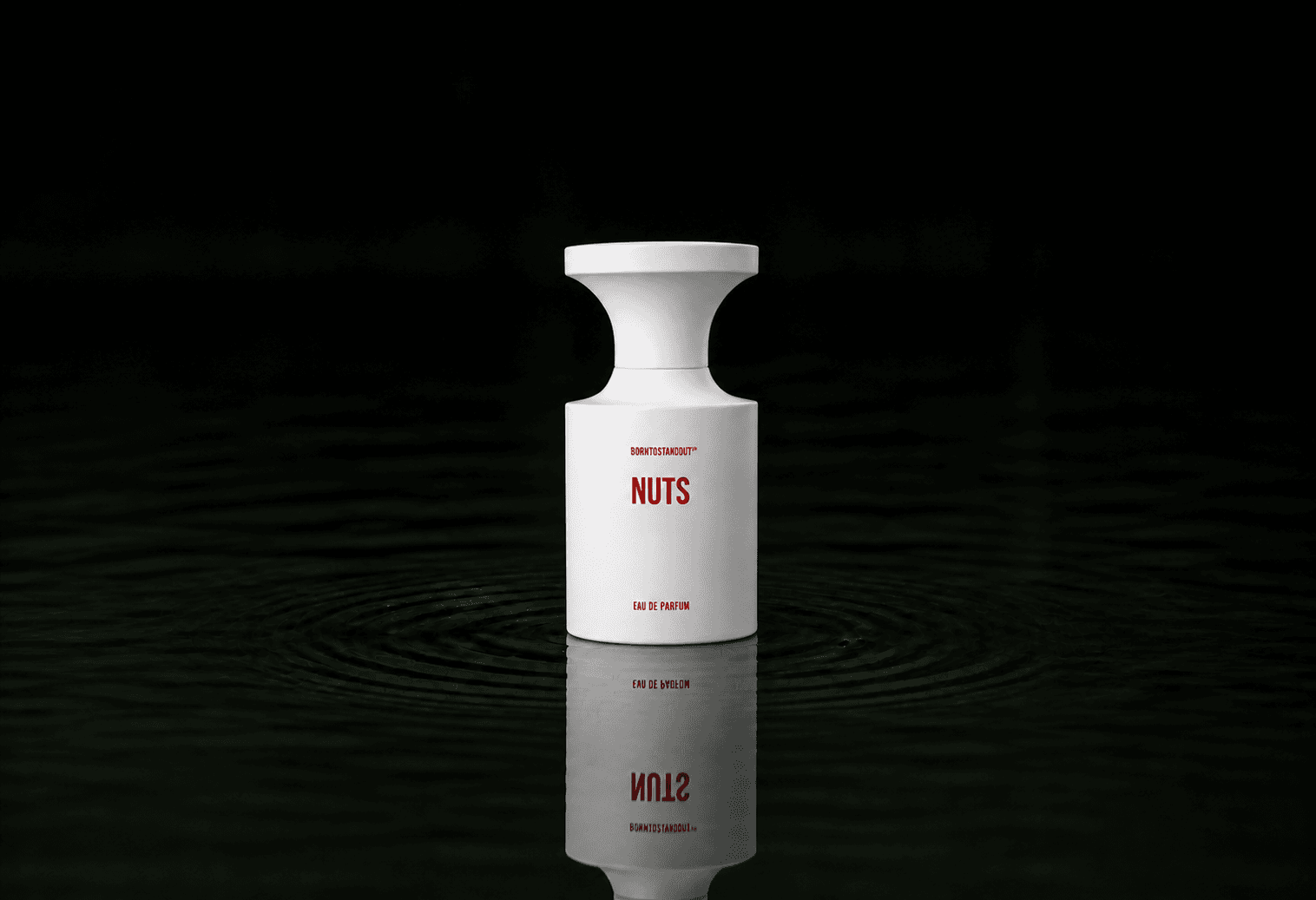BORNTOSTANDOUT Nuts fragrance bottle floating above dark water