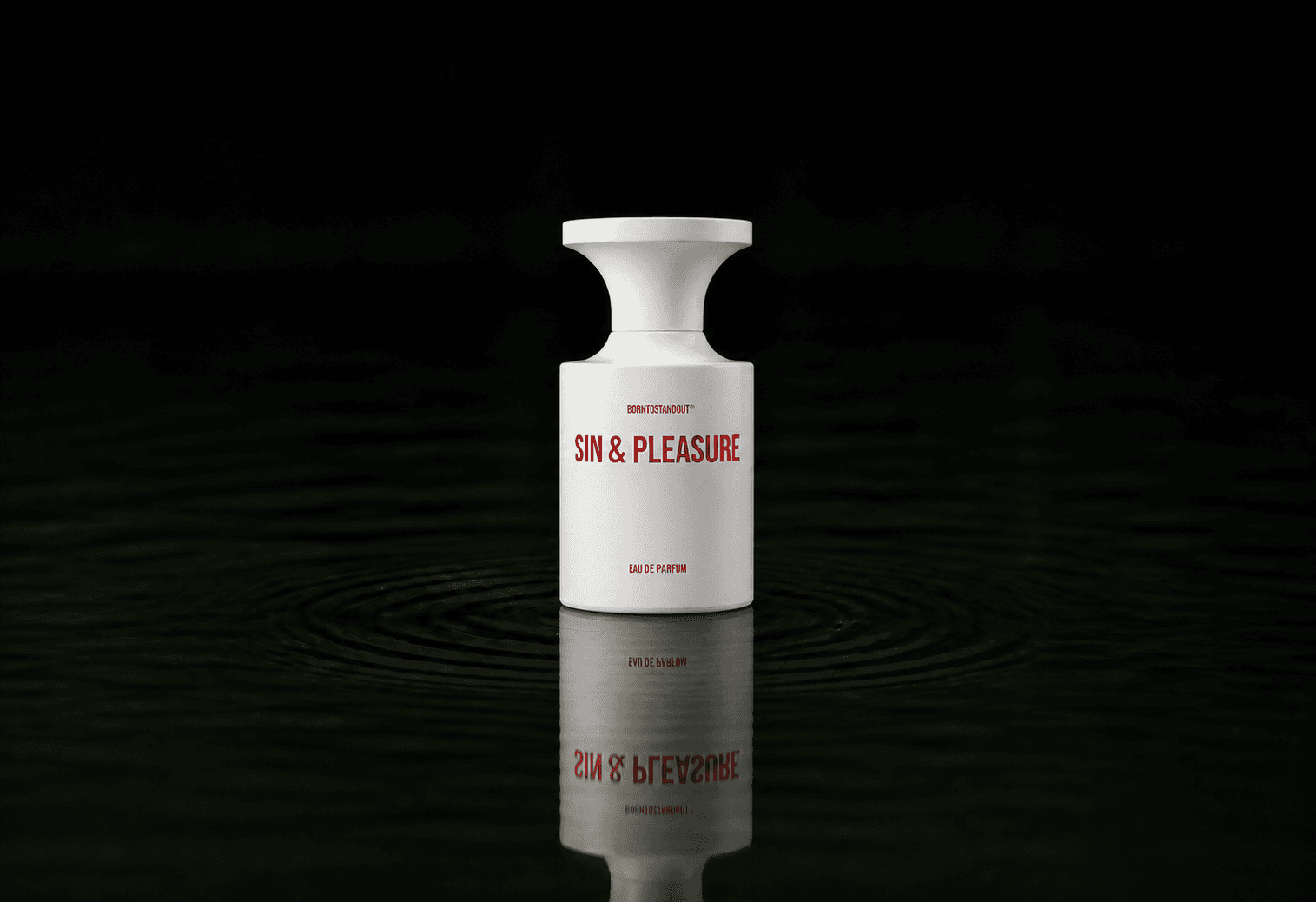 BORNTOSTANDOUT Sin & Pleasure fragrance bottle floating above dark water