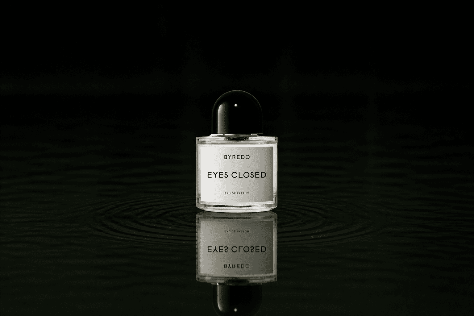 Byredo Eyes Closed fragrance bottle floating above dark water