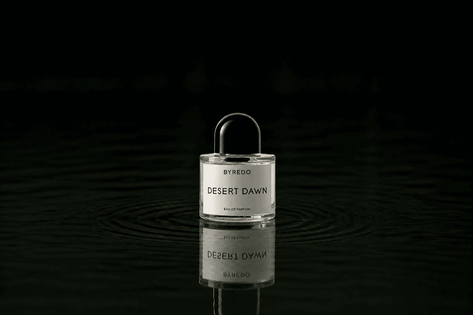 Byredo Parfums - Desert Dawn fragrance bottle floating above dark water