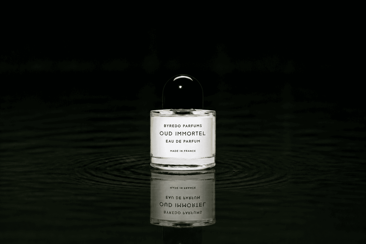 Byredo Parfums - Oud Immortel fragrance bottle floating above dark water