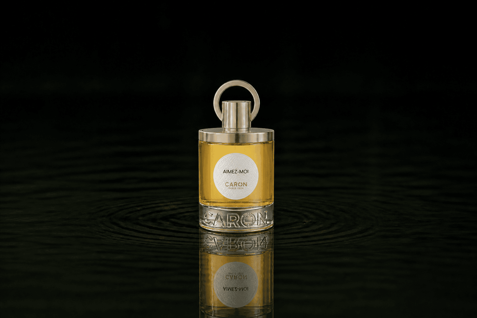 Caron Aimez-Moi fragrance bottle floating above dark water