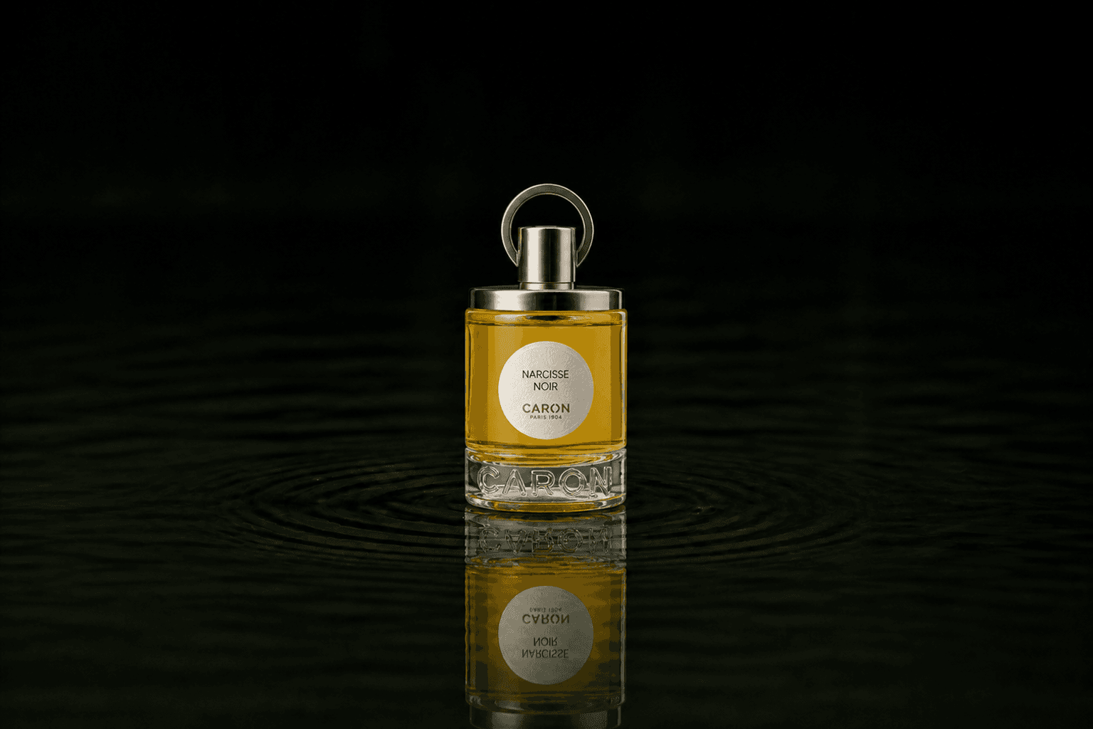 Caron Narcisse Noir Perfume fragrance bottle floating above dark water