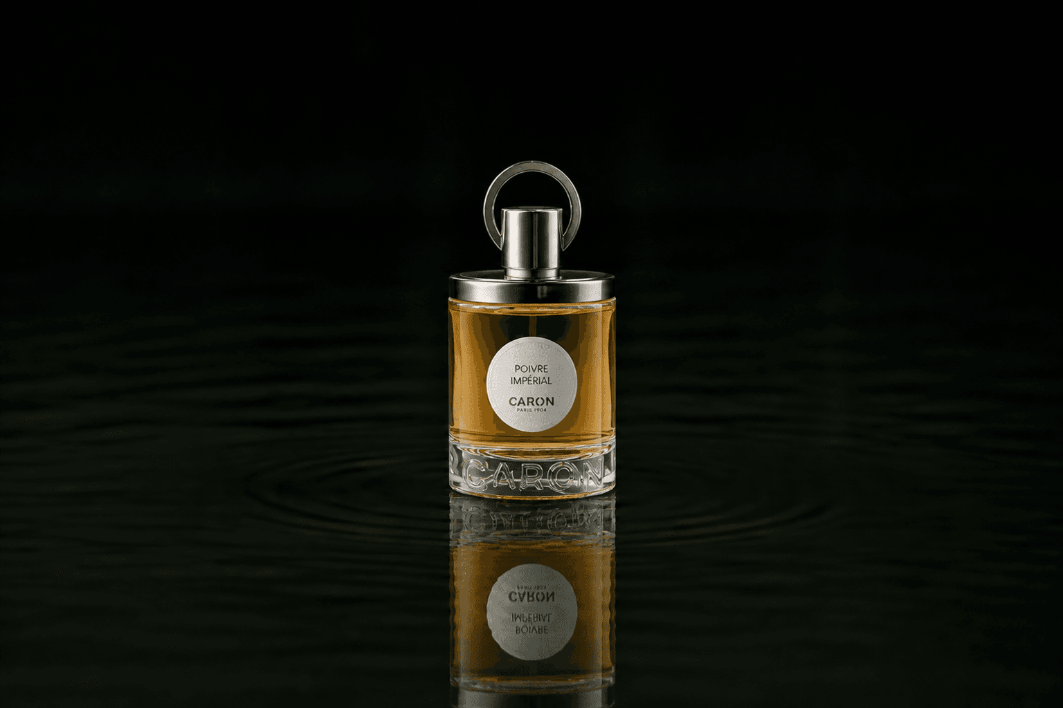 Caron Poivre Imperial fragrance bottle floating above dark water