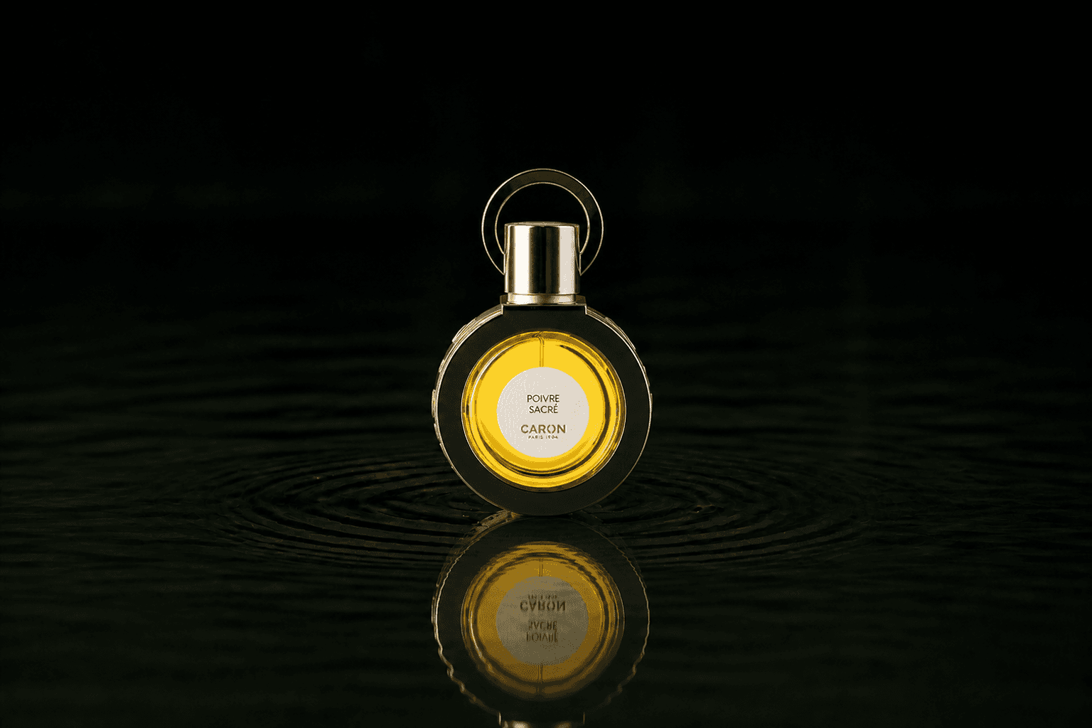 Caron Poivre Sacre fragrance bottle floating above dark water