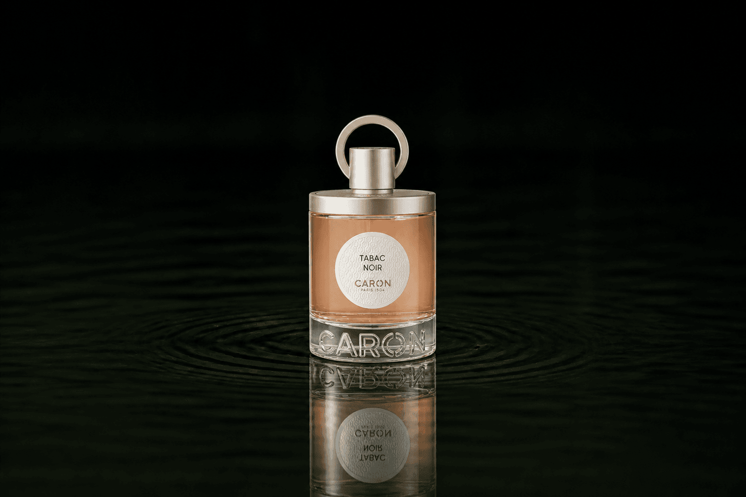 Caron Tabac Noir fragrance bottle floating above dark water