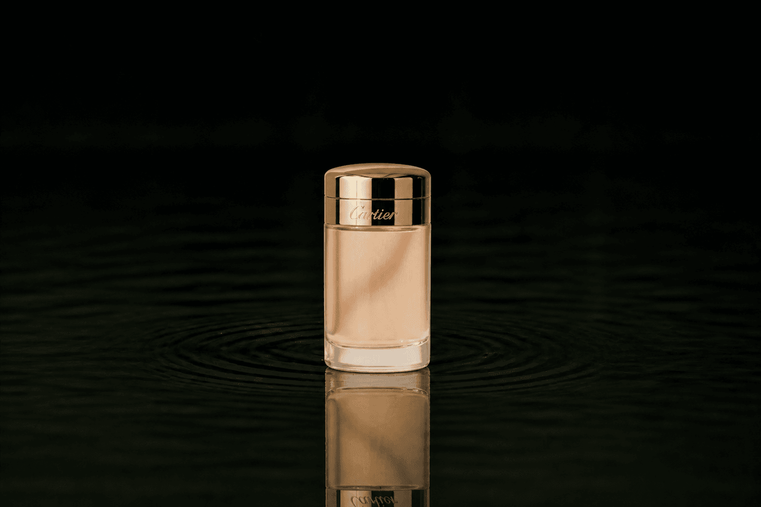 Cartier Baiser Vole Parfum fragrance bottle floating above dark water