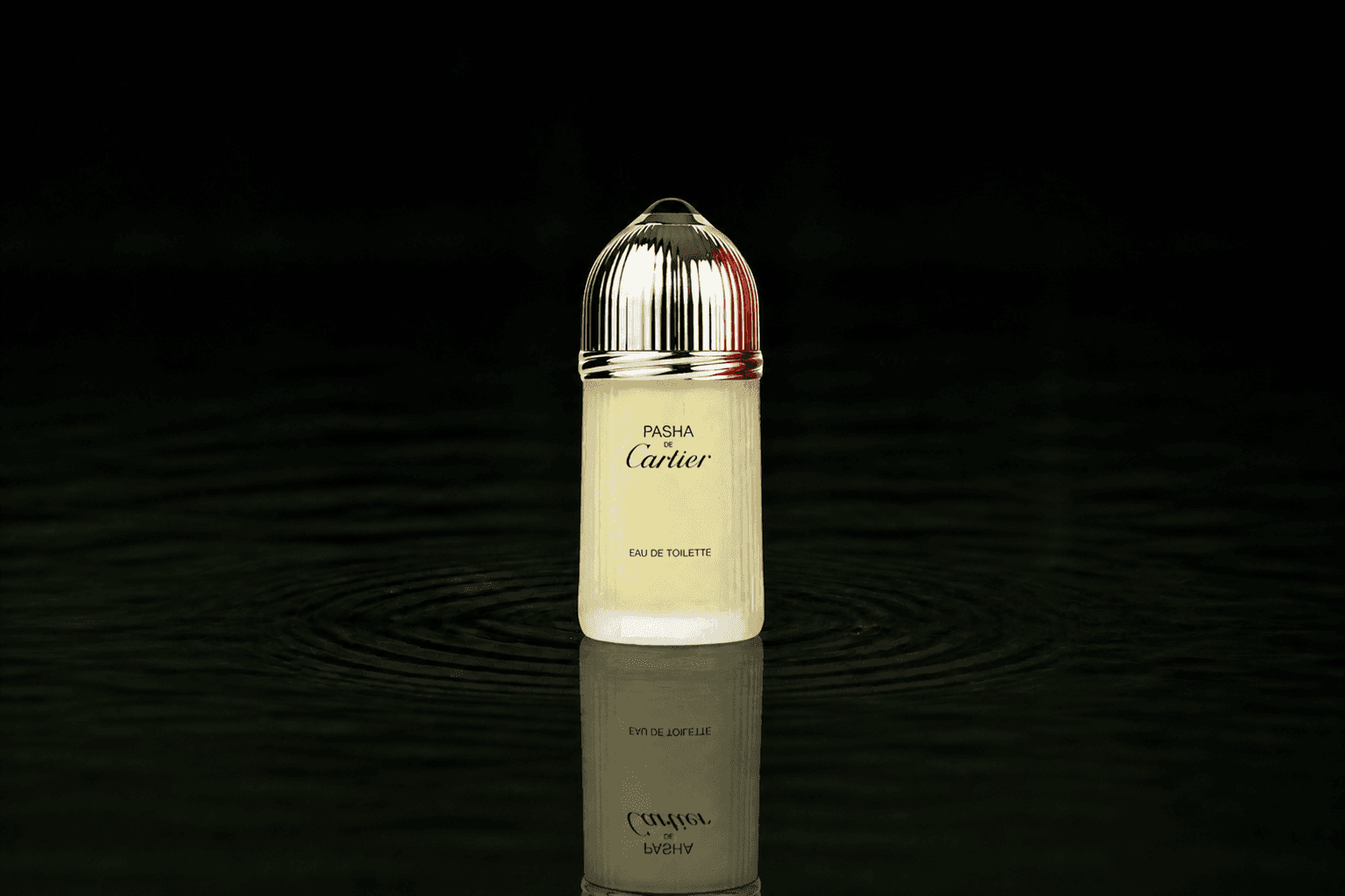 Cartier Pasha fragrance bottle floating above dark water
