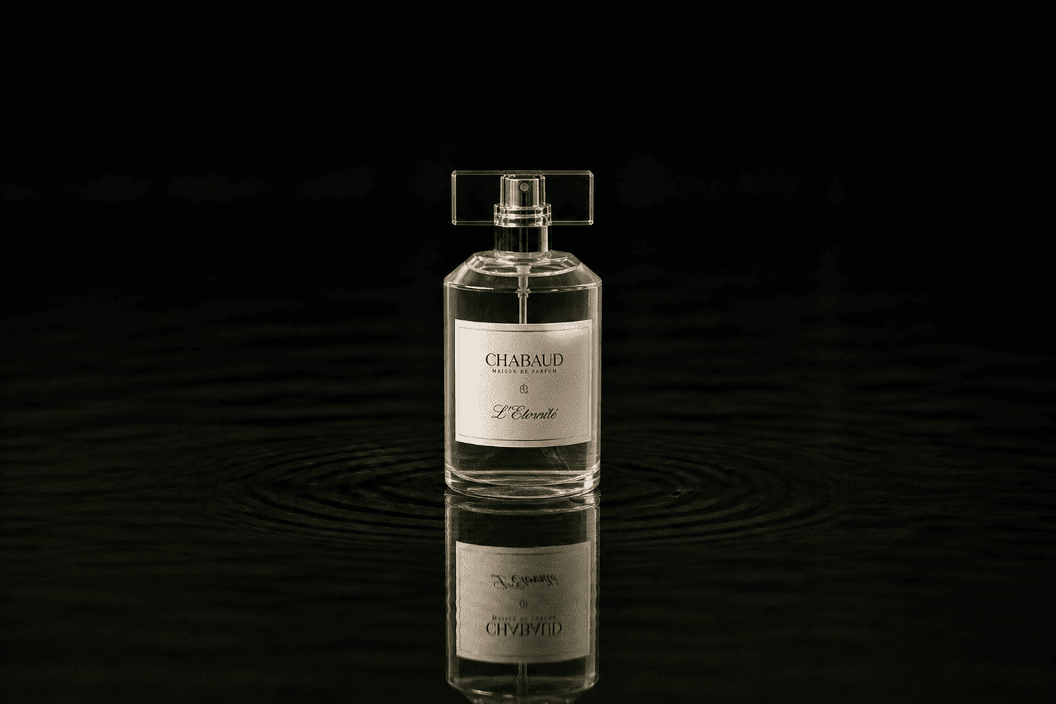Chabaud Lait Concentre fragrance bottle floating above dark water