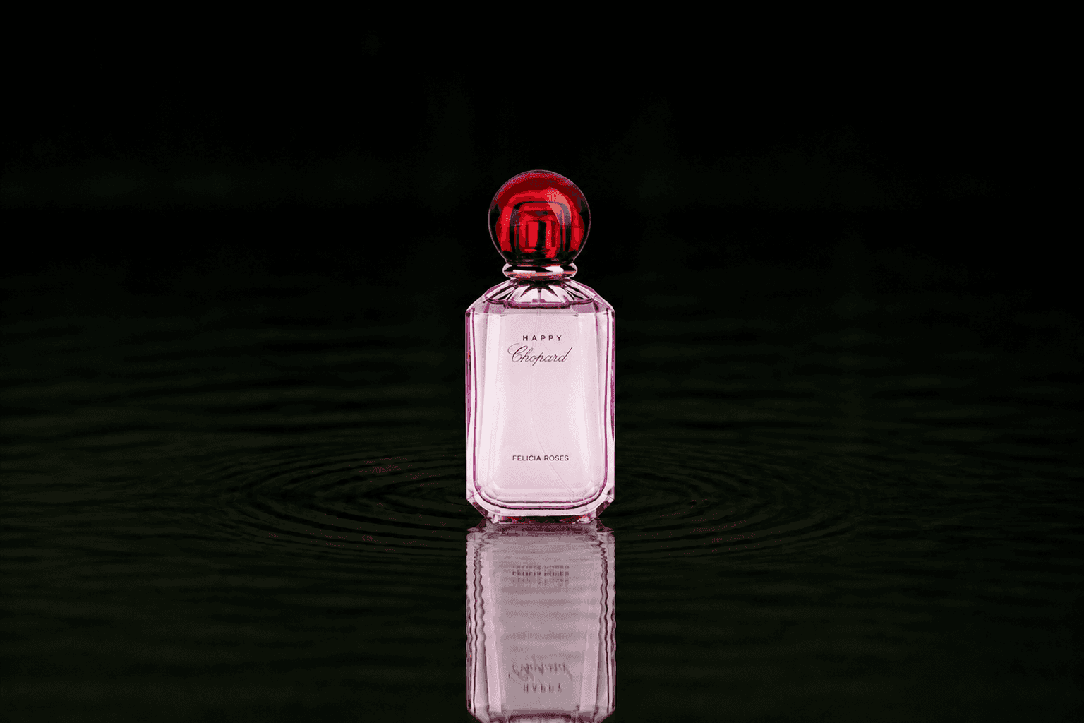 Chopard Happy Chopard - Felicia Roses fragrance bottle floating above dark water